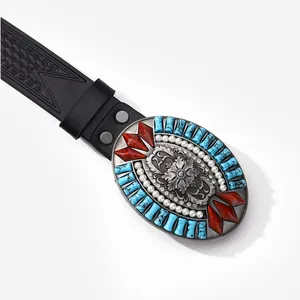 Macro view of vintage western belt buckle with turquoise stone and floral patterns