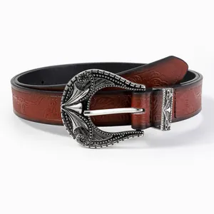 Detail of western retro belt with engraved silver buckle and embossed brown leather