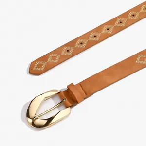 Dettaglio di cintura in pelle marrone con fibbia dorata e ricamo a rombi bianco