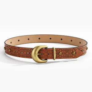 Detailed view of floral embossed brown leather belt with brass studs and C-shaped buckle