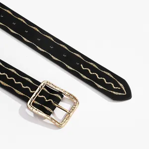 Close-up of a women belt with gold hammered buckle and wavy gold stitching details