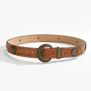 Détail d'une ceinture vintage en cuir marron avec gaufrage floral et boucle en bronze