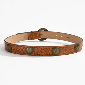 Détail de ceinture en cuir marron vintage avec motifs floraux et rivets en bronze