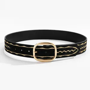 Detail of black suede belt featuring gold wave embroidery and an oval metal buckle