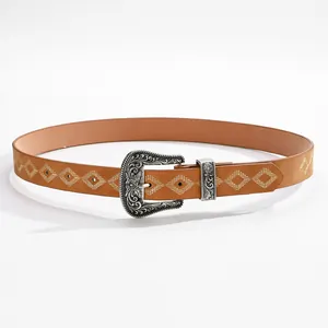 Dettaglio fibbia argento vintage con incisione floreale su cintura in pelle marrone