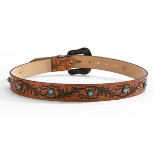 Detailed view of vintage western leather belt with embossed floral pattern and turquoise studs