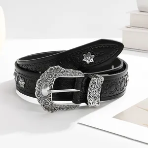 Detail of vintage black leather belt with silver star studs and ornate carved buckle