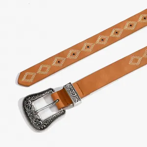Dettaglio di cintura in pelle marrone vintage con fibbia incisa e ricami gialli