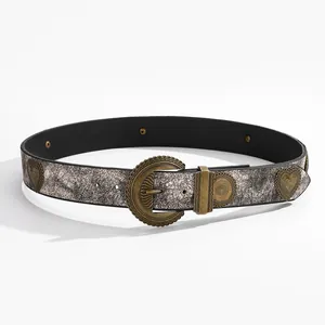 Détail de la boucle gravée en bronze et des clous en cœur sur la ceinture argentée