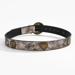 Détail de la ceinture vintage argentée avec ornements en forme de cœur en bronze
