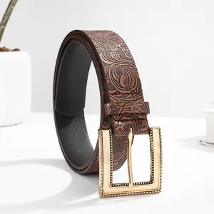 Detail view of a brown embossed leather belt with vintage floral patterns and gold buckle