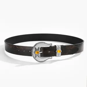 Detail of western style leather belt with carved silver buckle and amber gemstone inlay