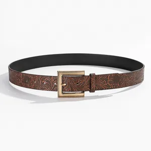 Detailed close-up of dark brown leather belt with vintage floral embossing and gold buckle
