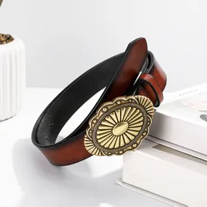 Ceinture vintage en cuir rouge-brun avec boucle ovale en laiton sur des livres