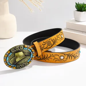 Detail view of Western cowboy belt with embossed floral pattern and turquoise metal buckle