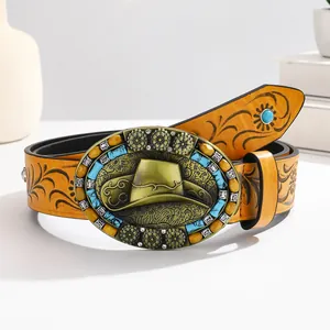 Detail of western cowboy leather belt featuring embossed floral patterns and turquoise buckle