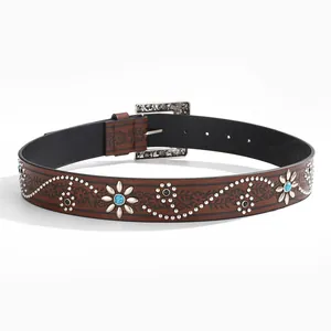 Close-up of western style belt with floral embossing, silver rivets and turquoise stones
