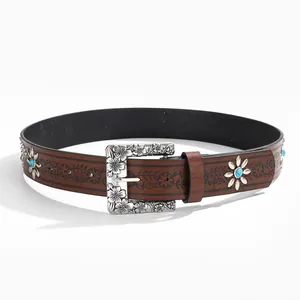 Detail of western leather belt with embossed flowers and turquoise daisy studs