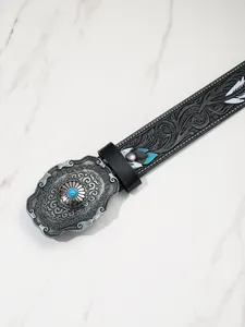 Détail de la boucle western avec pierre bleue et motifs gaufrés sur ceinture noire