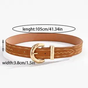 Détail d'une ceinture marron avec broderie ondulée et boucle ardillon dorée martelée