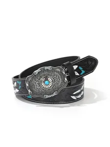 Détail de la boucle de ceinture western avec gravure florale et pierre turquoise centrale
