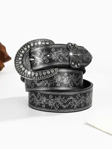Macro-opname van zwarte leren riem met bloemmotieven en ovale gesp met glanzende steentjes