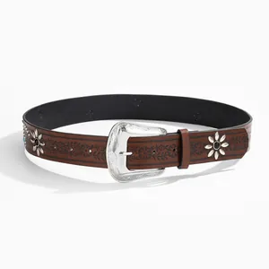 Close-up of brown leather belt with embossed floral patterns and silver carved buckle