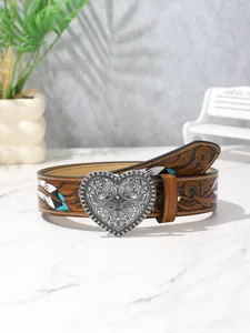 Dettaglio cintura in pelle marrone con piume a rilievo e fibbia a cuore intagliata