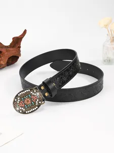 Macro-detail van reliëf zwarte lederen riem met vintage bronzen kralen bloemgesp