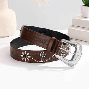 Brown leather belt with floral embossing, metal studs, and a carved silver buckle