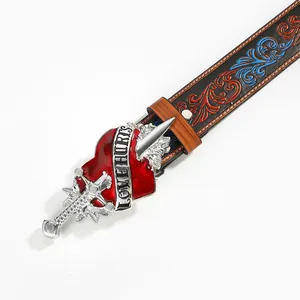 Detailed shot of vintage belt buckle featuring a sword piercing a heart with Love Hurts text