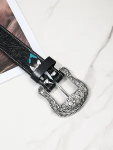 Vue détaillée d'une boucle de ceinture western gravée avec motifs floraux argentés vintage