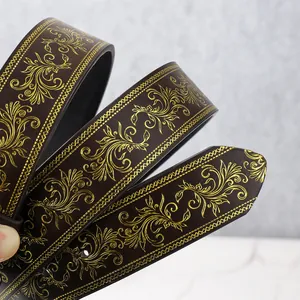 Detailaufnahme von dunkelbraunem Ledergürtel mit goldenen Rankenmustern und Webkanten