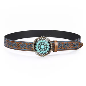 Macro detail of western belt buckle with turquoise stone and floral embossed leather