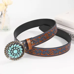 Detail of vintage belt featuring floral turquoise buckle and baroque leather pattern