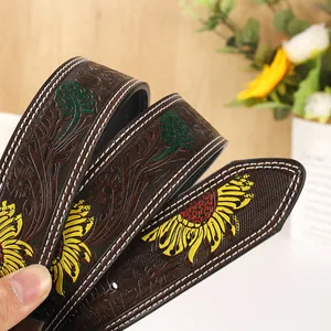 Macro shot of dark brown embossed leather belt with colorful sunflower painted patterns