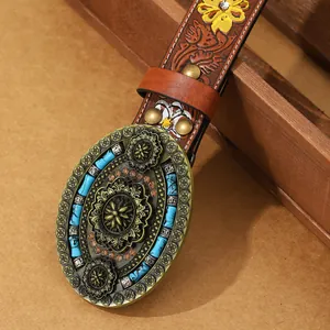 Detail of bohemian PU belt with floral embossing and bronze mandala buckle with turquoise