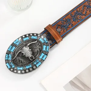 Nahaufnahme der Western-Gürtelschnalle mit Stierschädel-Relief und blau geprägtem Leder