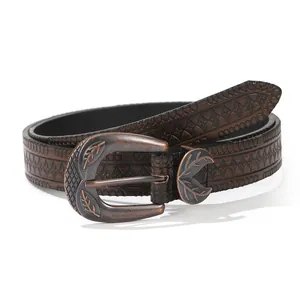 Dettaglio cintura in pelle marrone scuro con goffratura etnica e fibbia in bronzo antico