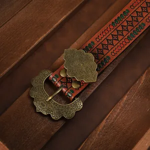 Close-up of vintage bronze buckle with floral relief and embossed leather belt details