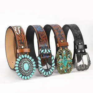 Detail of bohemian western belts with embossed leather and turquoise inlaid buckles
