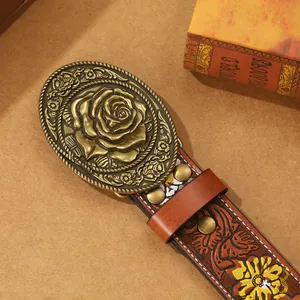 Detail of vintage embossed PU leather belt with bronze floral buckle and metal studs