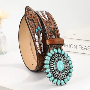 Close-up of vintage brown leather belt with turquoise buckle and floral embossing