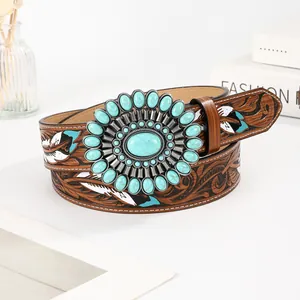 Detail of bohemian embossed leather belt with turquoise stone buckle and feather patterns