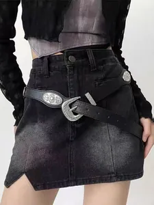Close-up of black western leather belt with engraved silver buckle and punk metal details