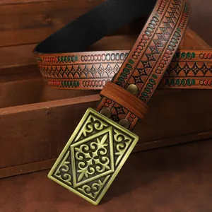 Close-up of vintage brown leather belt with embossed patterns and antique bronze buckle