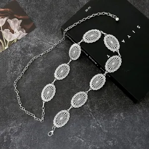 Vintage western silver metal waist chain with engraved oval links on dark stone background
