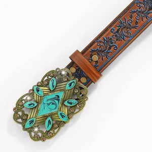 Macro detail of bohemian brown leather belt with turquoise stones and floral engravings