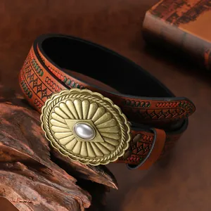 Detail of vintage western leather belt with embossed patterns and brass pearl buckle