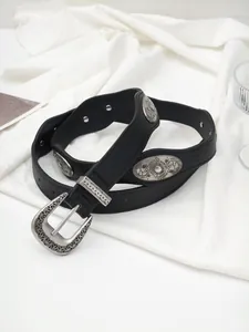 Macro detail of vintage Western black leather belt with silver floral metal ornaments